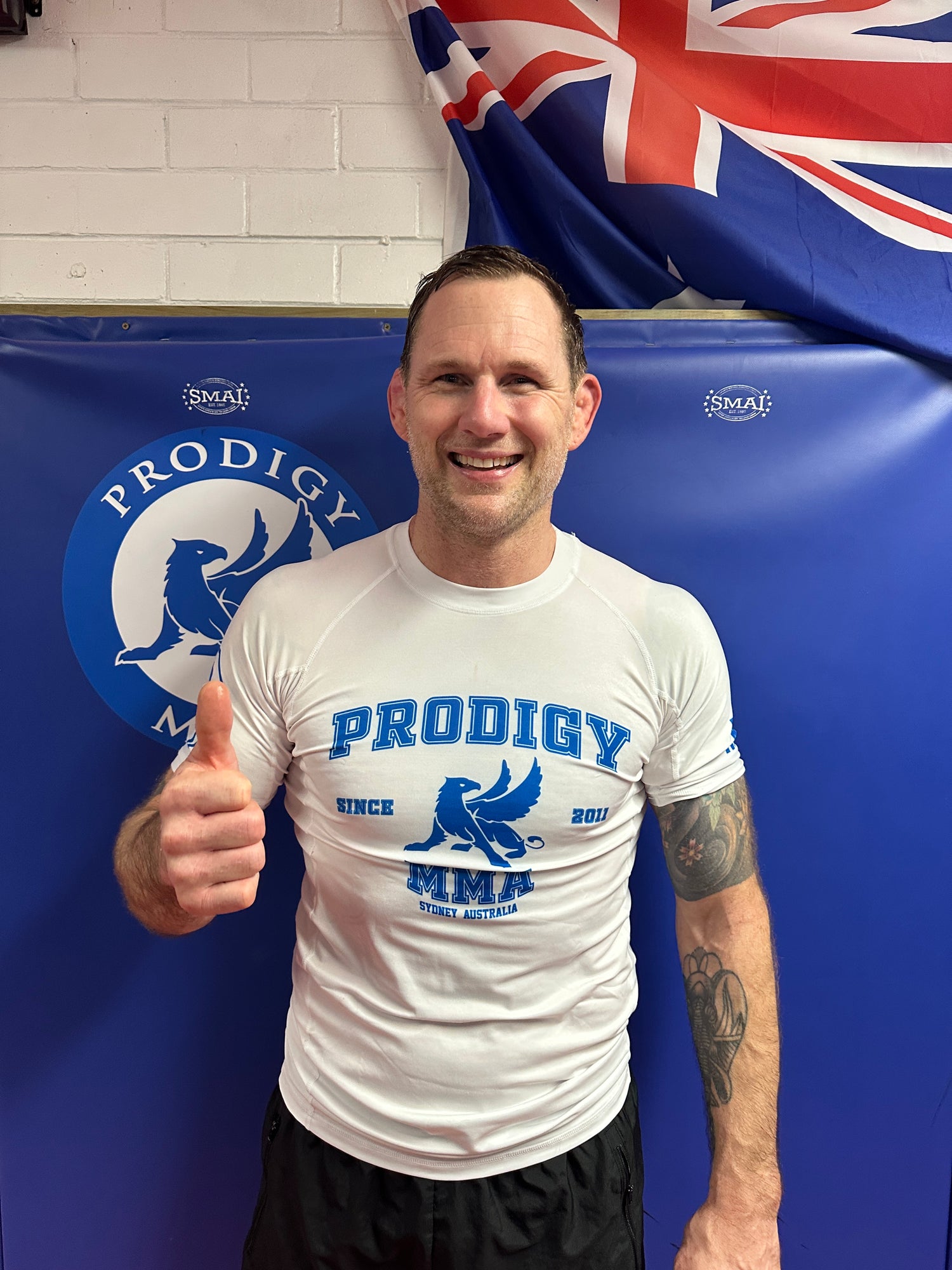 Person wearing a 'Prodigy' t-shirt in front of a blue banner with branding.