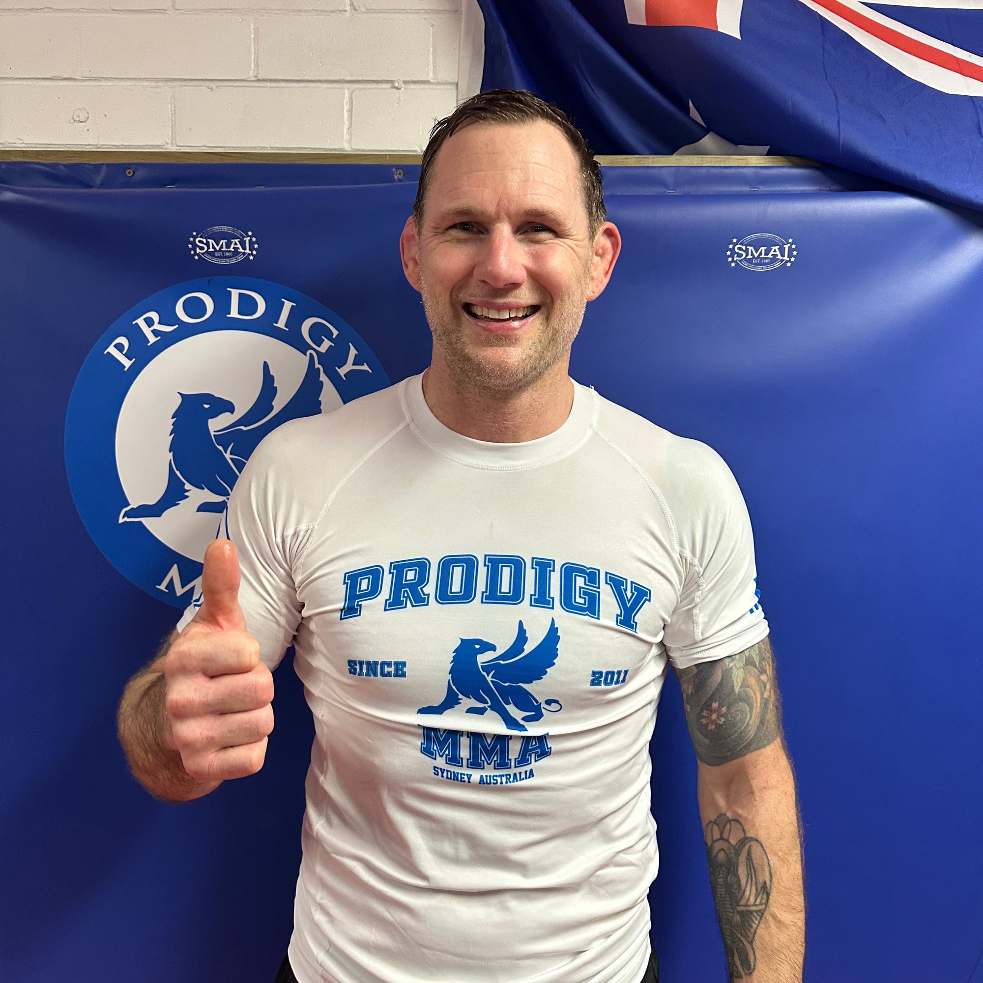 Person wearing a 'Prodigy' t-shirt in front of a blue banner with branding.