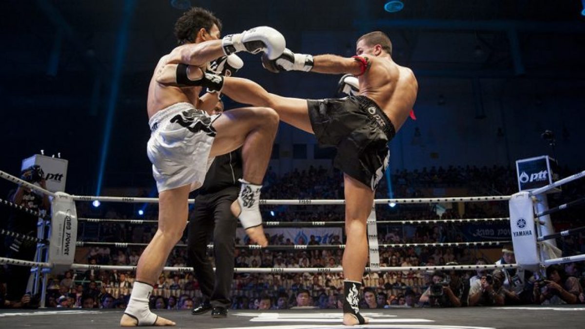 Two boxers in a boxing ring with a referee in the background.